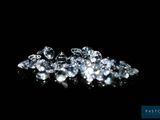 a close up of a pile of diamonds on a black surface