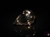 un gros plan d'un diamant posé sur une table, sur fond noir