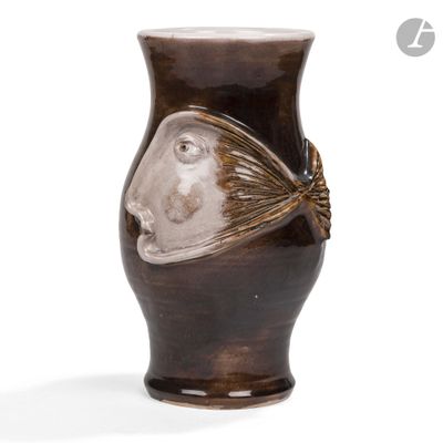 un vase marron orné d'un visage sur fond blanc