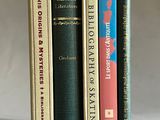 trois livres sont empilés sur une table