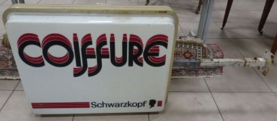a sign that says coffure on it in the middle of a tiled floor