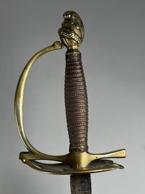une vieille épée en bronze dont la poignée est ornée d'une tête de lion