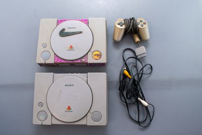 deux consoles de jeux vidéo posées l'une à côté de l'autre sur une table