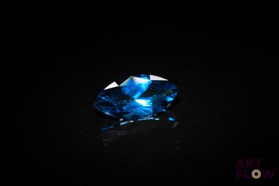 gros plan d'un diamant bleu sur une surface noire