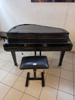 a piano and stool in a room with a painting on the wall
