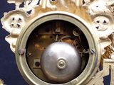a gold clock with a silver ball in the middle of it