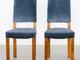 a pair of blue velvet chairs with wooden legs