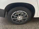 a white van with a black rim parked on the side of the road
