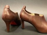 brown leather high heeled shoes on a gray surface