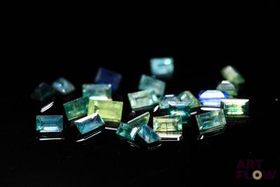 some green and blue glass pieces on a black surface