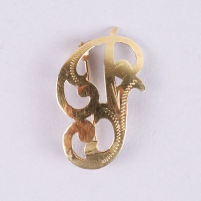 an image of a gold brooch with the letter b on it