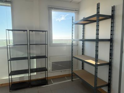 a room with shelves and a window in it