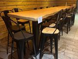 Des tables et des chaises sont alignées dans une pièce aux murs lambrissés.
