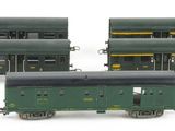 three green and yellow train cars sitting next to each other on a white surface