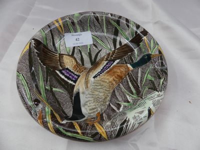 une assiette sur laquelle est peint un oiseau, posée sur une table