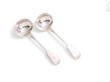 pair of silver spoons on a white surface with a white background