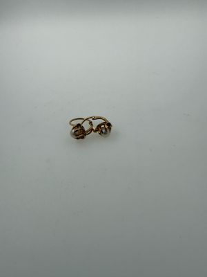 two gold rings sitting on top of a white surface