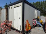 a small building that has a lot of signs on the side of it