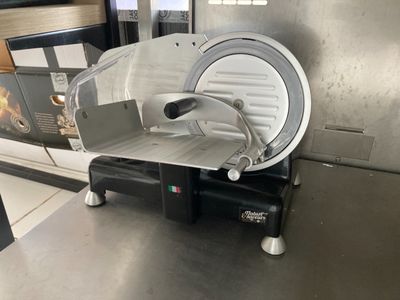 une trancheuse à viande posée sur un plan de travail dans une cuisine