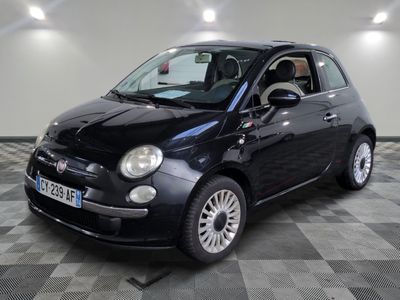 la photo d'une petite voiture noire sur un sol en damier