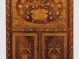 une armoire ancienne en bois dont la porte est ornée d'un motif floral