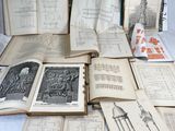 many old books sitting on a table with drawings on them