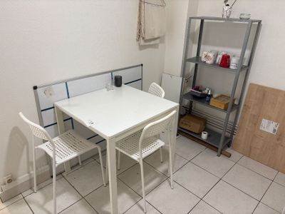 a white table and two chairs in a small room