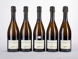 quatre bouteilles de vin sont alignées sur une table