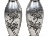 paire de vases en argent ornés de motifs floraux sur fond blanc