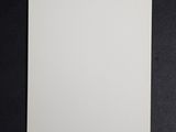a close up of a white square card on a black surface