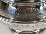 a silver bowl with a lid on a white table