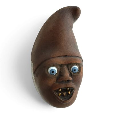 un masque marron aux yeux bleus sur un mur blanc