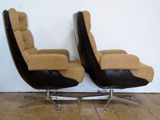 pair of mid - century lounge chairs with black leather upholstered seats