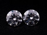 une paire de diamants de taille ronde sur un fond noir