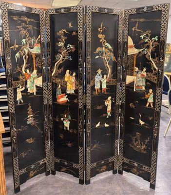 une image représentant un paravent noir orné de motifs asiatiques
