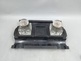 two salt and pepper shakers sitting on top of a black tray