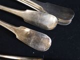 four spoons and a fork on a black table