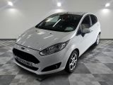 La voiture blanche est garée sur le sol à damier du garage.