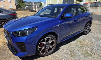 La voiture bleue est garée sur le bord de la route.