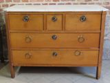 une commode en bois avec un plateau en marbre, posée sur un sol carrelé