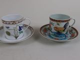 two cups and saucers sitting on a table