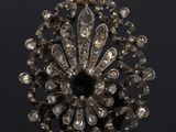 a close up of a diamond broochle on a black surface