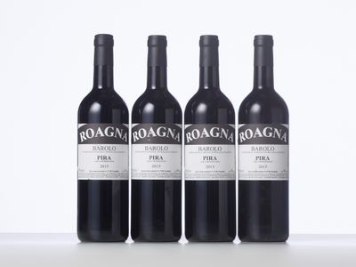 three bottles of red wine sitting on top of a white table