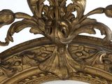 a mirror that has a gold frame with a bird on it