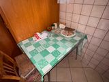 une table recouverte d'une nappe verte, dans un coin de la pièce