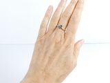 a woman ' s hand holding a ring with a blue stone