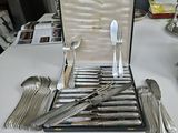 a case with silverware on a table with silverware on it