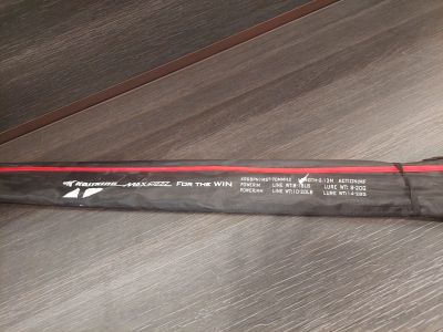 un parapluie noir et rouge posé sur un plancher en bois