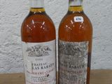 deux bouteilles de vin posées sur une table l'une à côté de l'autre