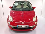 a small red car that is parked in a white room
